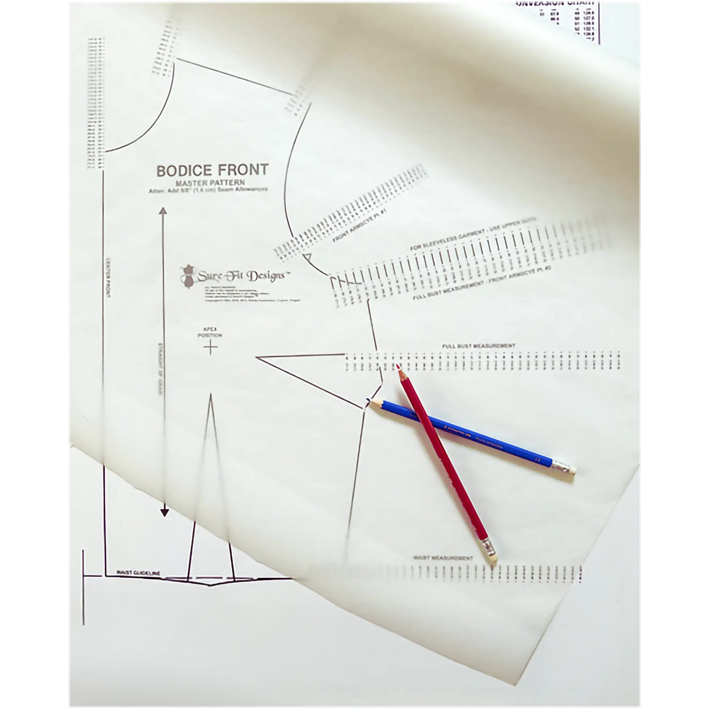 A close-up of sewing pattern paper with printed bodice front measurements and guides, overlaid with two pencils, one red and one blue.