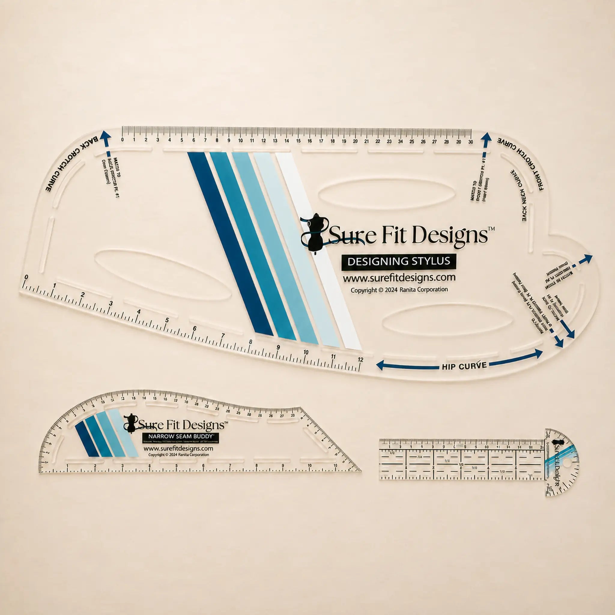 Three transparent patternmaking tools with teal stripes by Sure Fit Designs, a Designing Stylus, a Narrow Seam Buddy, and a Curved T-Square displayed on a pale maple table