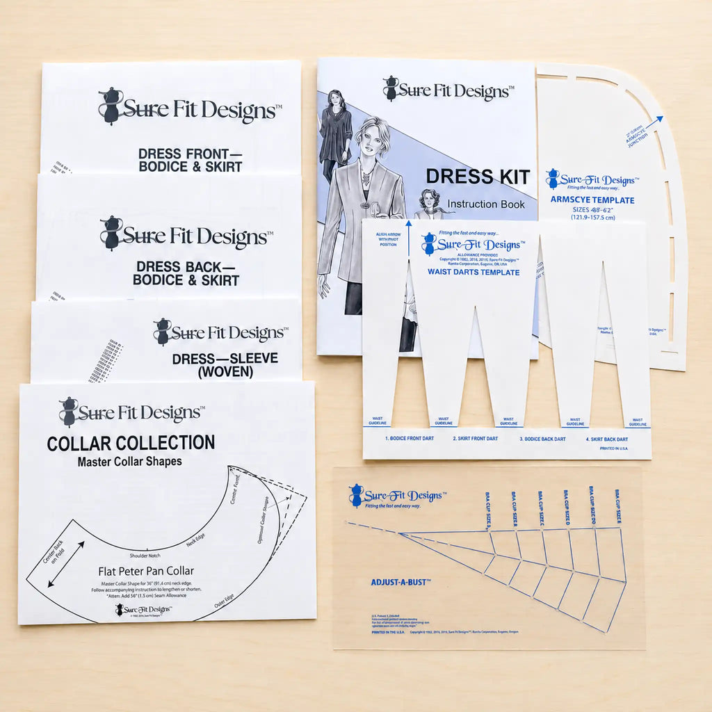A flat-lay of Sure Fit Designs sewing pattern packaging and templates on a light wood background, including instruction booklets, collar collection sheets, and armhole/shoulder templates.