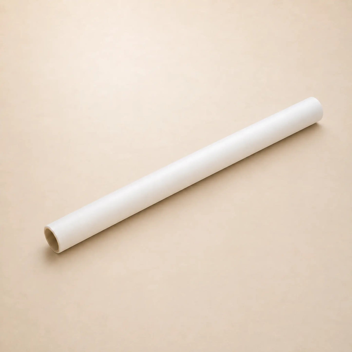 One roll of transparent vellum lying diagonally on a plain beige background.
