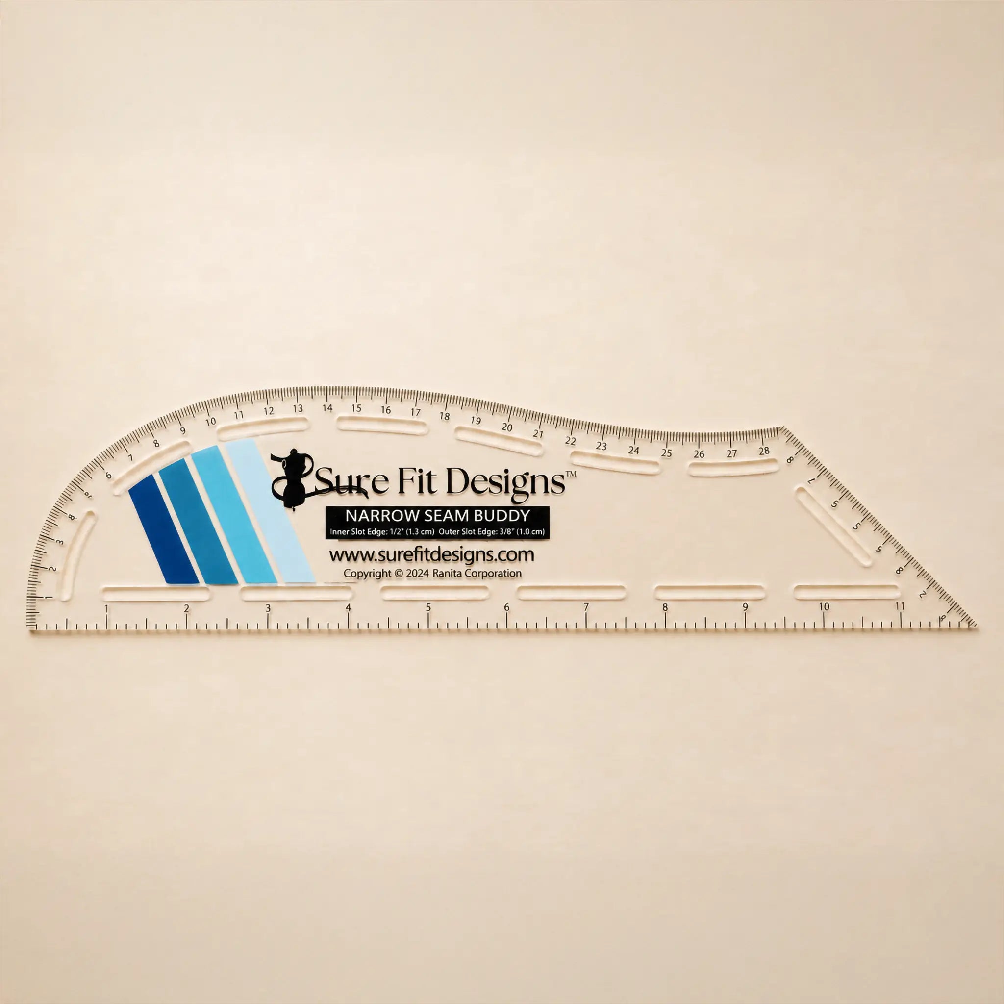 A clear plastic curved measuring ruler with printed measurement markings and the Sure Fit Designs logo, shown on a plain light beige background.
